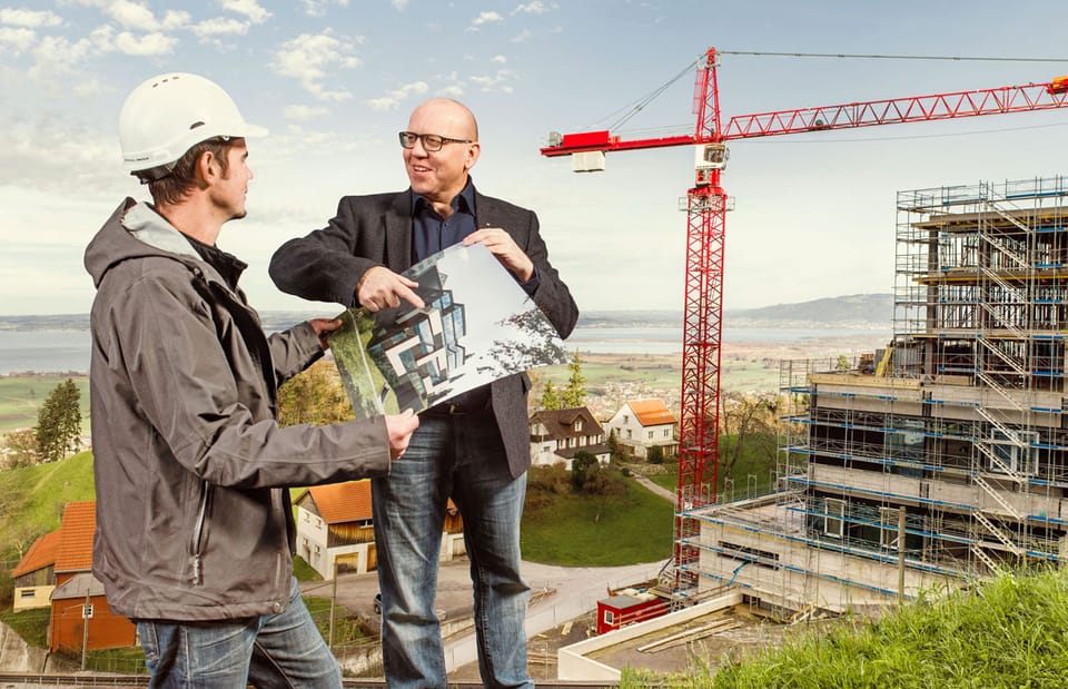 Bauherr und Bauleiter bereden auf der Baustelle, wie die fertige Immobilie aussehen soll
